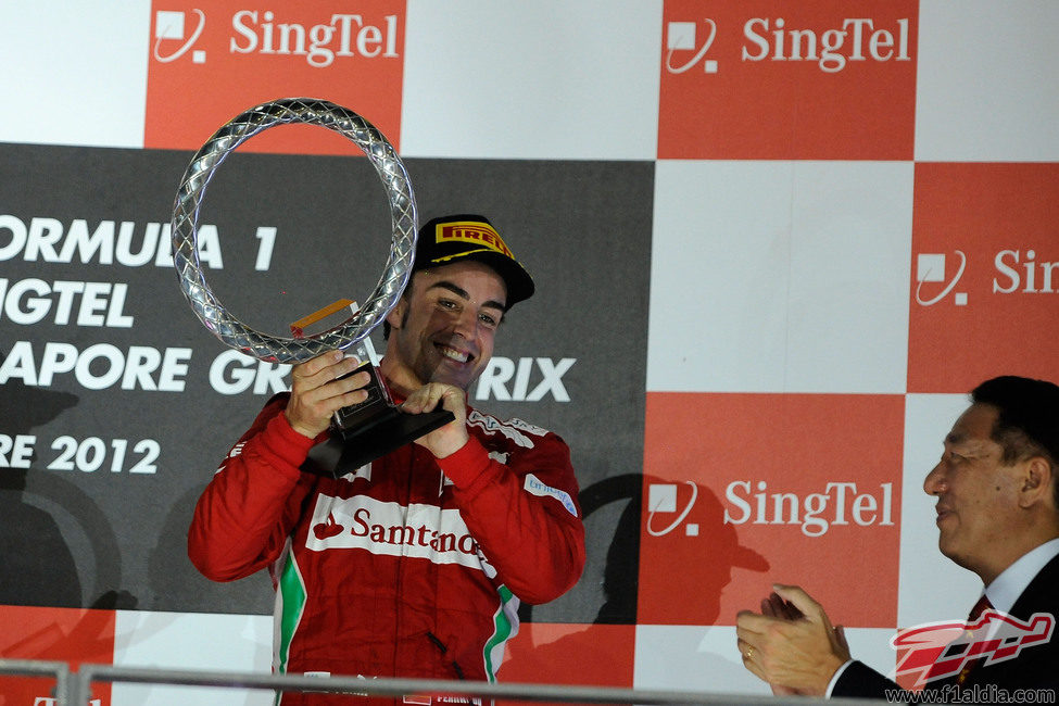 Fernando Alonso sostiene el trofeo en el podio