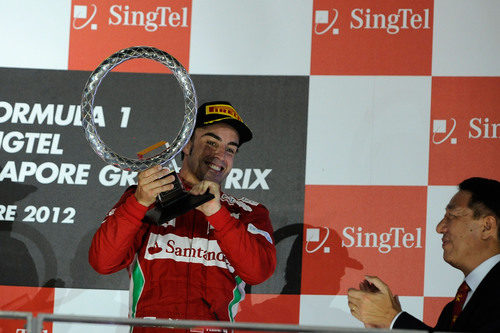 Fernando Alonso sostiene el trofeo en el podio
