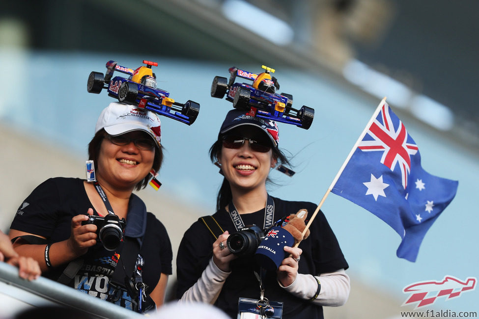 Dos aficionadas japonesas de Red Bull con coches en la cabeza