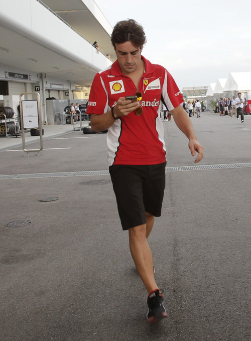 Fernando Alonso mira el móvil en el 'paddock' de Suzuka