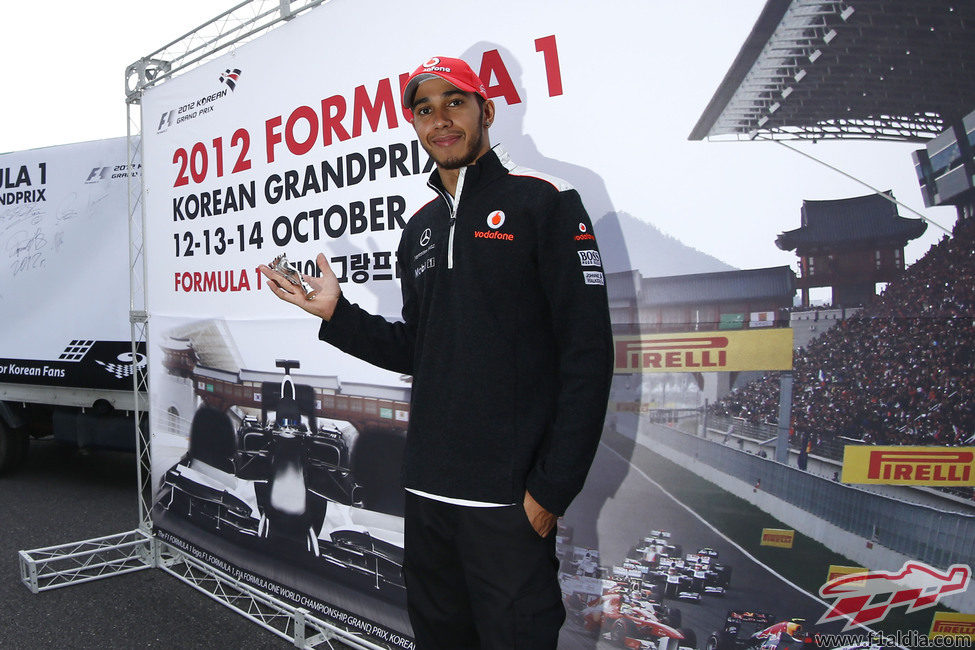 Lewis Hamilton posa ante un cartel promocional del GP de Corea