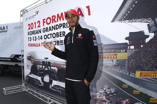 Lewis Hamilton posa ante un cartel promocional del GP de Corea