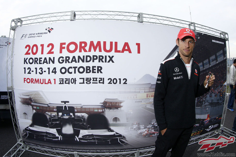 Jenson Button posa ante un cartel promocional del GP de Corea