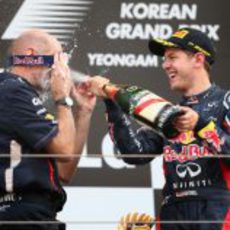 Vettel empapa a Adrian Newey con champán en el podio de Corea 2012