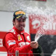Fernando Alonso descorcha champán en el podio de India 2012