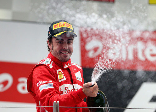 Fernando Alonso descorcha champán en el podio de India 2012