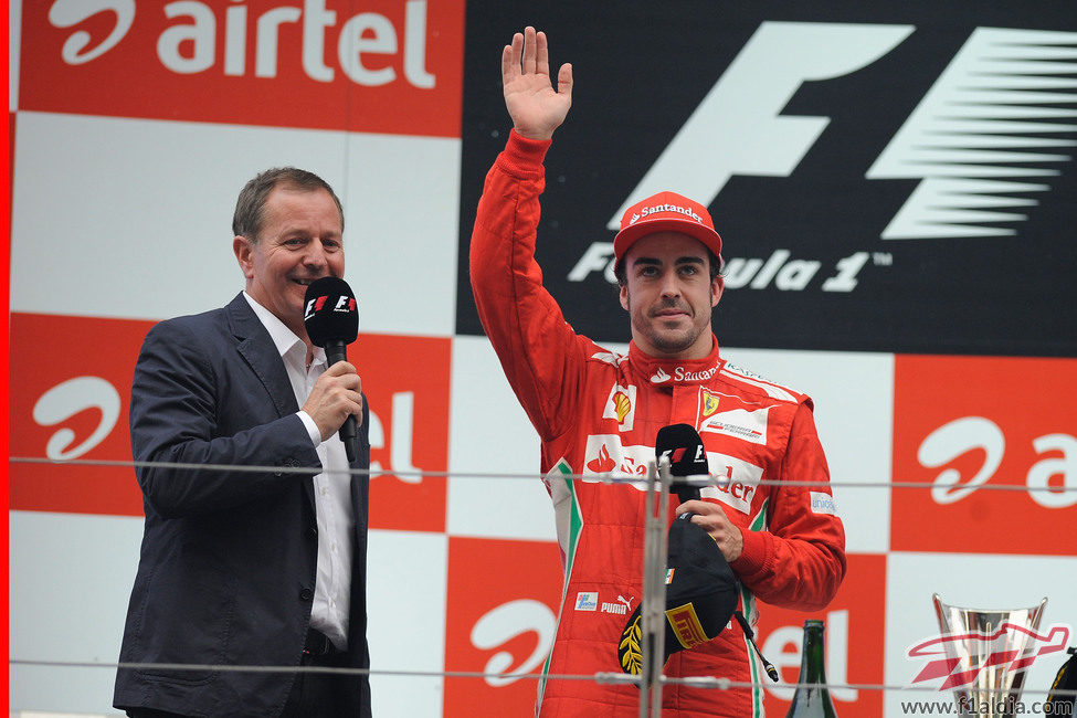 Fernando Alonso saluda desde el podio junto a Martin Brundle