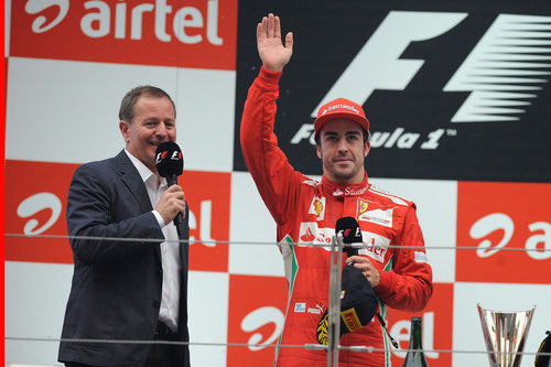 Fernando Alonso saluda desde el podio junto a Martin Brundle