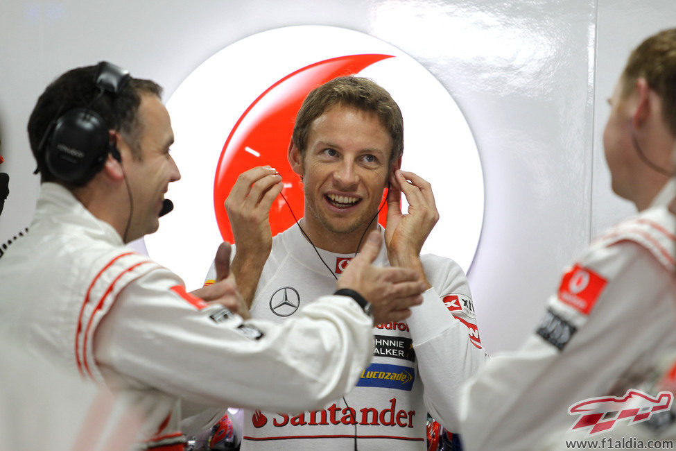 Jenson Button charla con sus ingenieros en el box