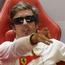 Fernando Alonso señala algo dentro del box de Ferrari