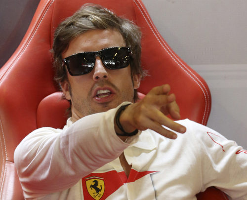 Fernando Alonso señala algo dentro del box de Ferrari