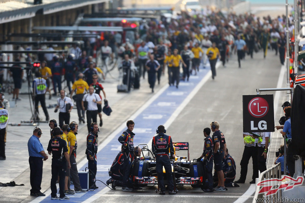 Los mecánicos de Red Bull preparan el coche de Vettel en el pit lane