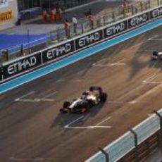 Narain Karthikeyan pasa por la recta de Yas Marina seguido de Nico Rosberg