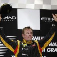 Kimi Räikkönen alza los brazos en el podio de Abu Dabi