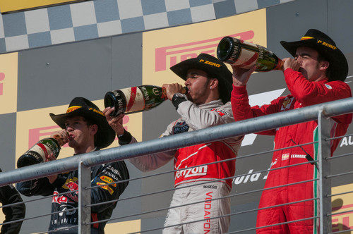 Los tres pilotos beben champán en el podio de Austin