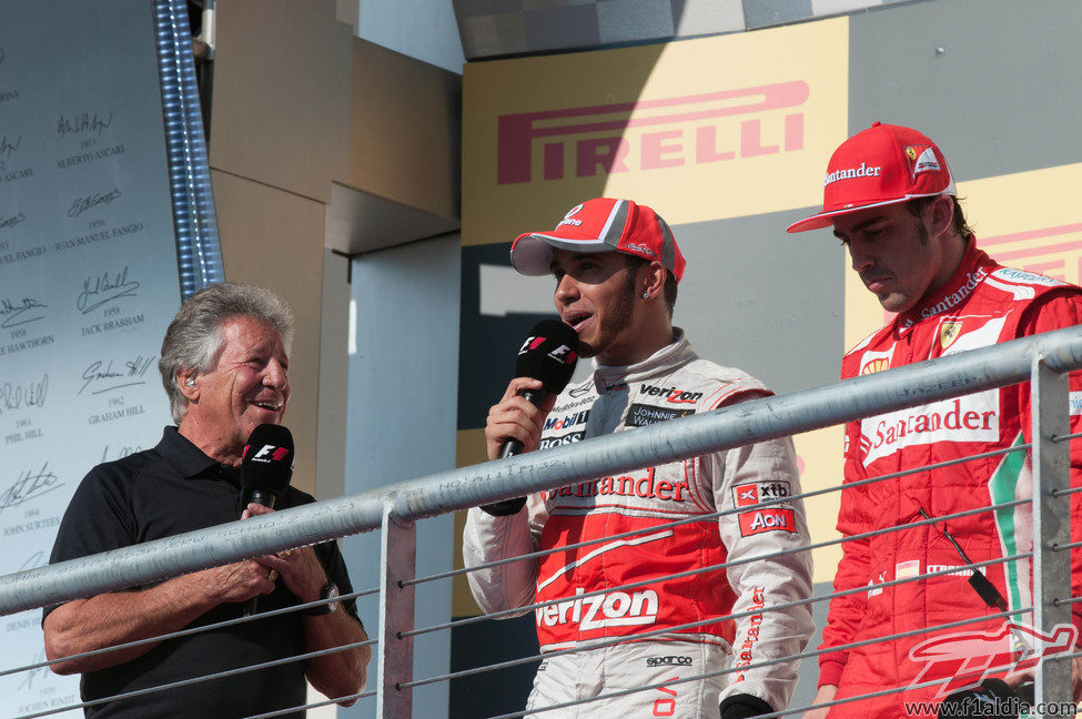 Mario Andretti entrevista a Hamilton y Alonso en el podio