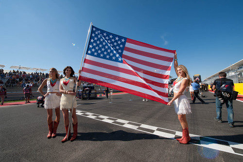 Tres 'pit babes' sujetan la bandera de Estados Unidos