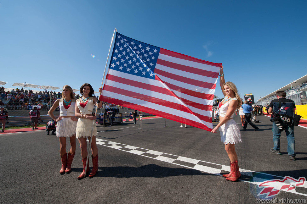 Tres 'pit babes' sujetan la bandera de Estados Unidos