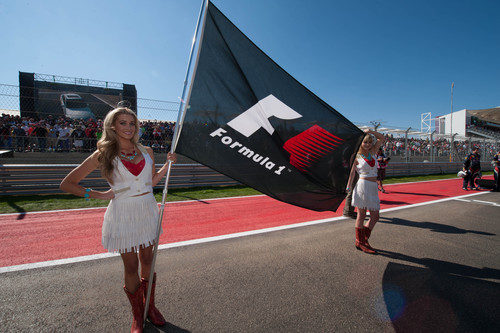 Dos 'pit babes' sujetan la bandera de la Fórmula 1