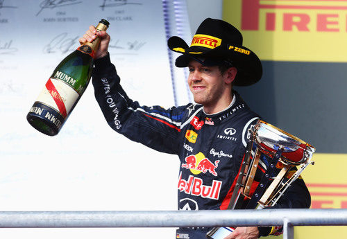 Vettel levanta la botella de champán en el podio de EE.UU.