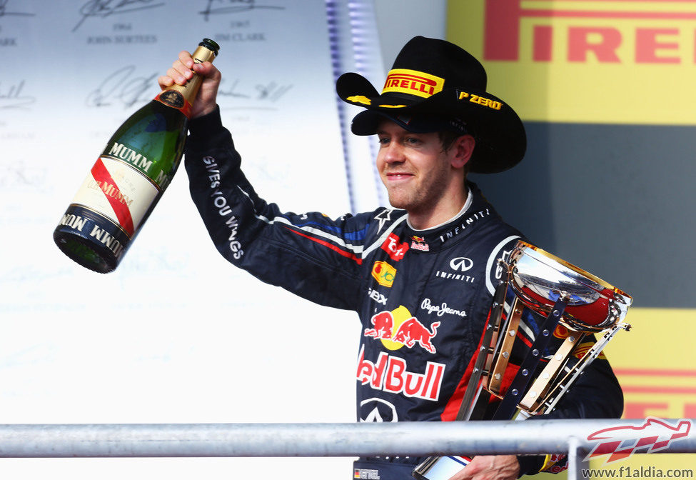 Vettel levanta la botella de champán en el podio de EE.UU.