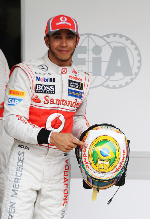 Lewis Hamilton señala su casco tras lograr la 'pole' en Brasil 2012