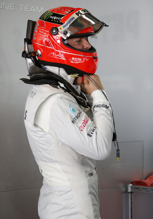 Michael Schumacher se ajusta el casco en el garaje de Mercedes