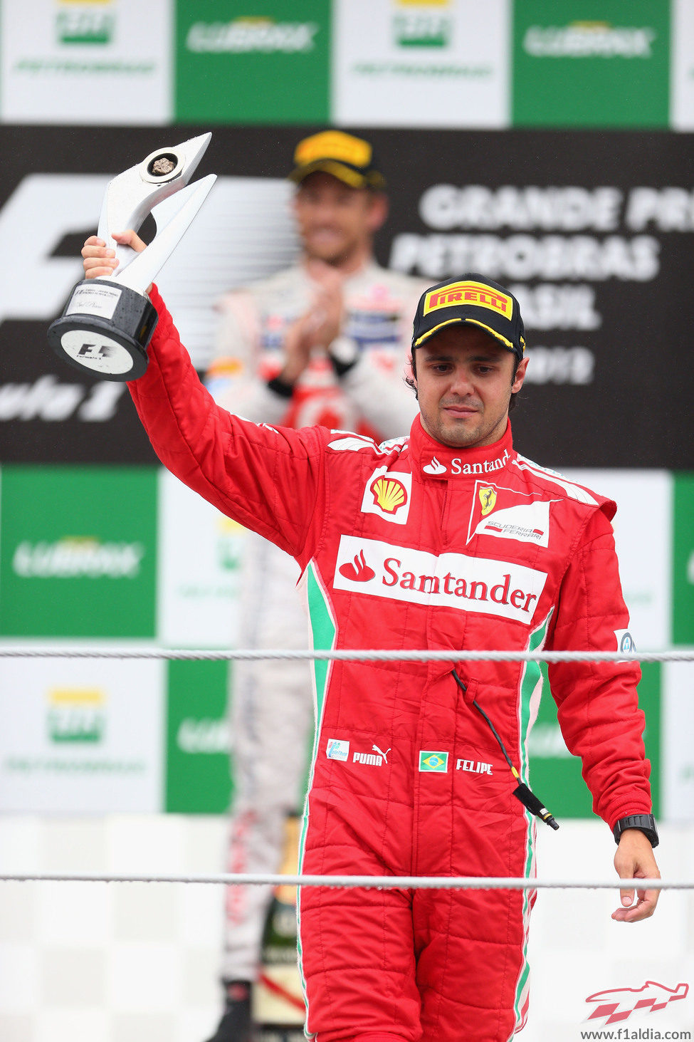 Felipe Massa levanta su trofeo de tercero en el GP de brasil 2012