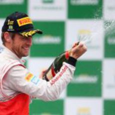 Jenson Button descorcha el champán en Brasil 2012