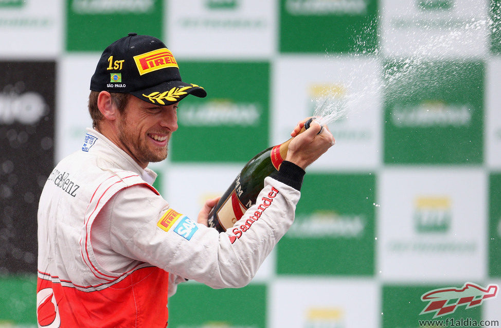 Jenson Button descorcha el champán en Brasil 2012