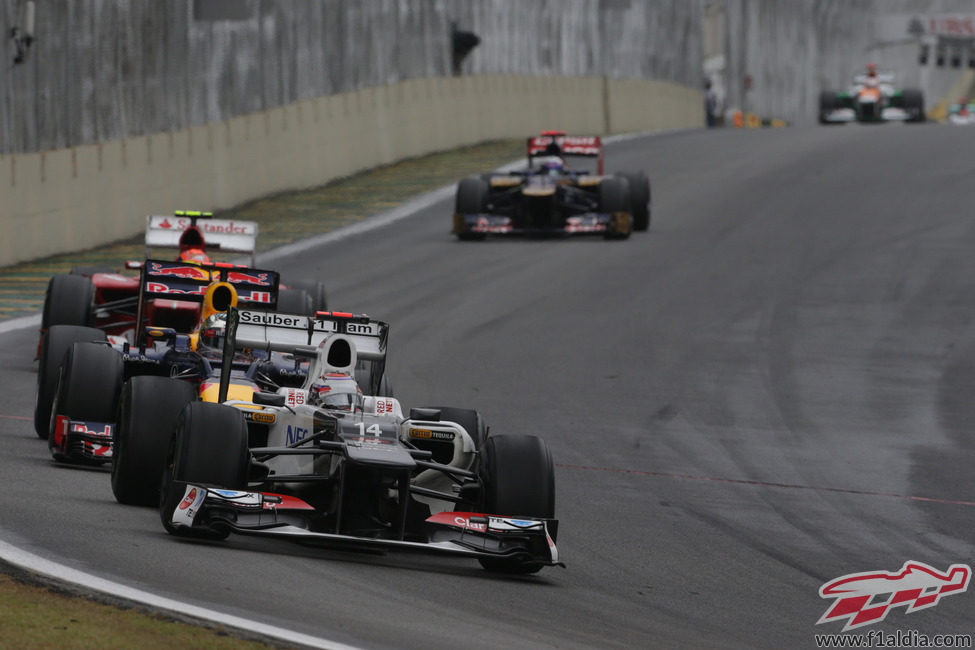Kamui Kobayashi rueda por delante de Sebastian Vettel