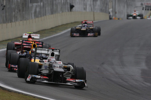 Kamui Kobayashi rueda por delante de Sebastian Vettel