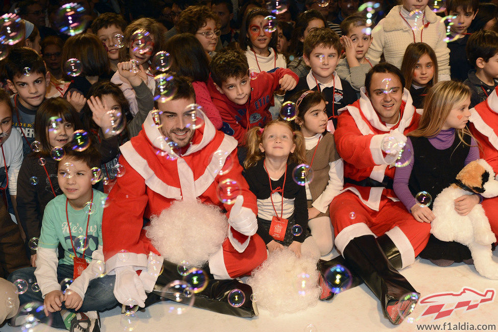 Fernando Alonso y Felipe Massa con los niños