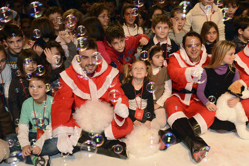 Fernando Alonso y Felipe Massa con los niños