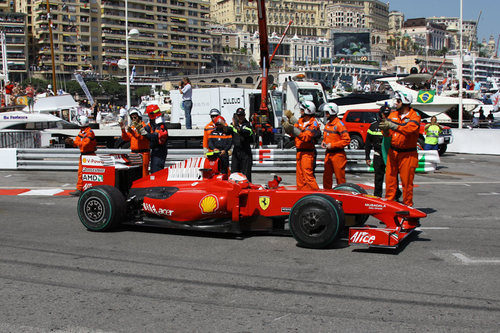 Raikkonen pasa junto a los operarios de la grúa