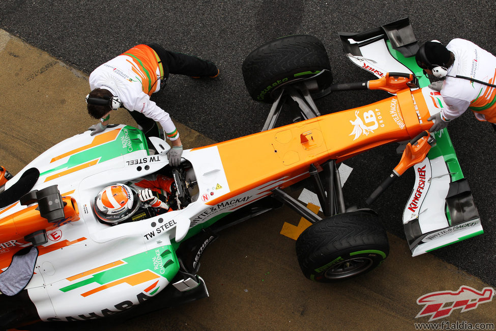 Los mecánicos empujan el Force India de Adrian Sutil al box