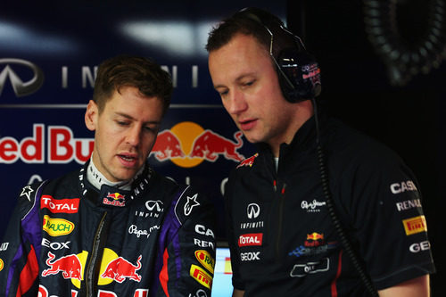Sebastian Vettel habla con uno de sus mecánicos en el garaje