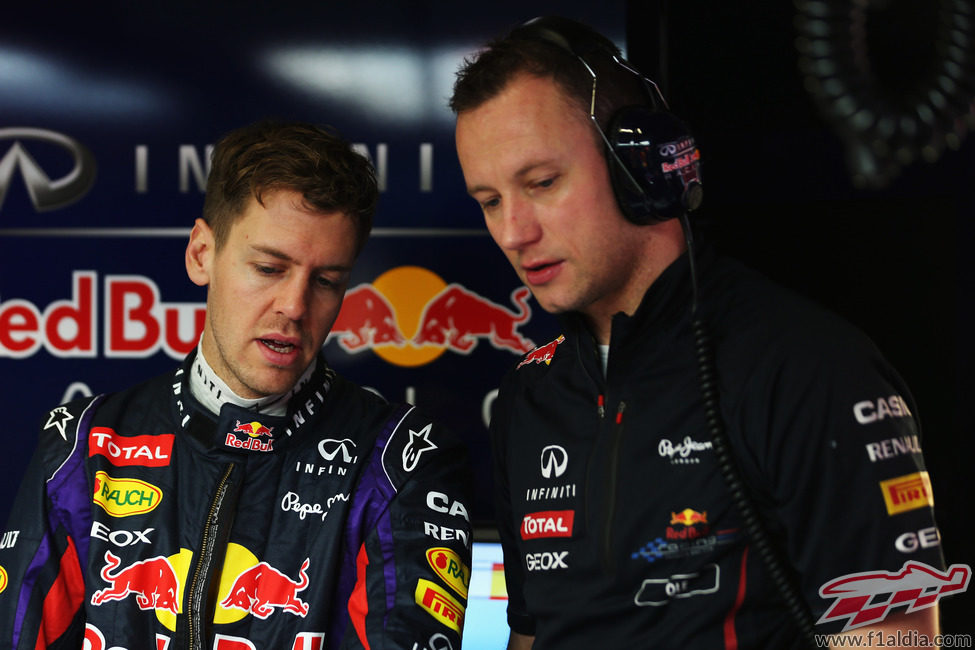 Sebastian Vettel habla con uno de sus mecánicos en el garaje