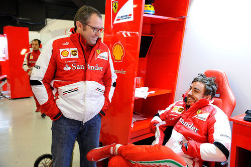 Stefano Domenicali y Fernando Alonso sonrientes en el box