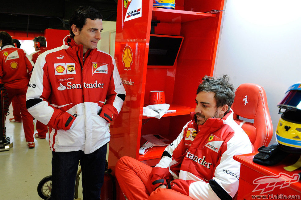 Fernando Alonso y Pedro de la Rosa hablan en el garaje de Ferrari