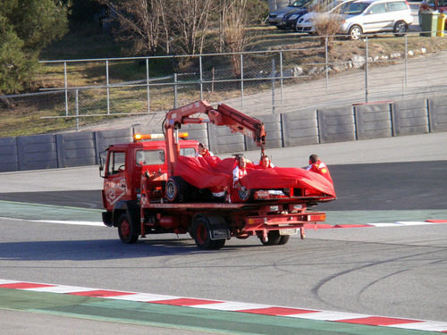 La grua carga con el Ferrari F138 de Felipe Massa