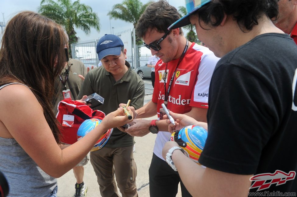 Fernando Alonso firma autógrafos en Sepang