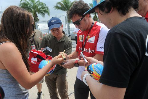 Fernando Alonso firma autógrafos en Sepang