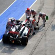Los mecánicos de McLaren empujan el coche de Jenson Button