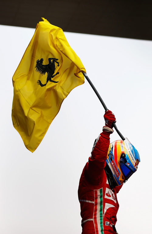 Fernando Alonso alza la bandera de Ferrari