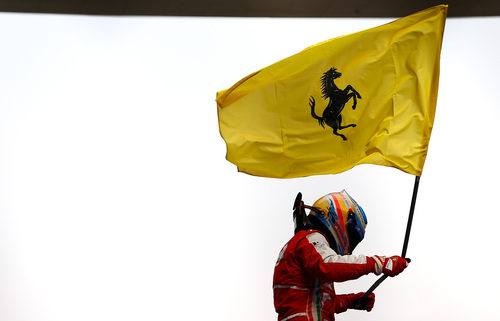 Fernando Alonso celebra su victoria con la bandera de Ferrari