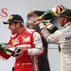 Lewis Hamilton rocía de champagne a Fernando Alonso