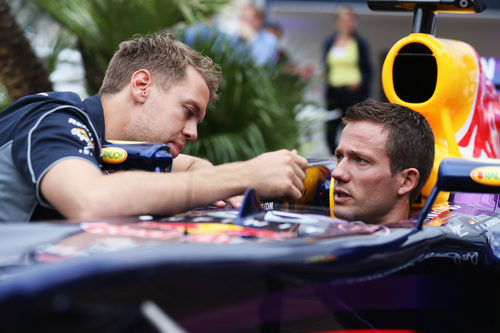 Sebastian Vettel le muestra el monoplaza a Sebastien Ogier