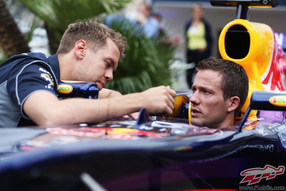 Sebastian Vettel le muestra el monoplaza a Sebastien Ogier