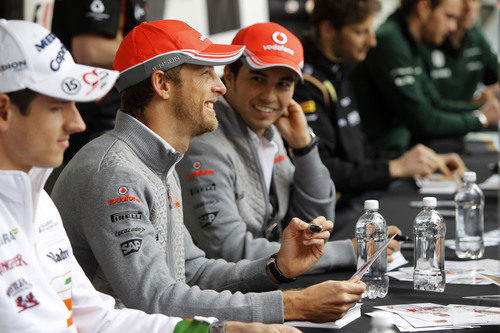 Jenson Button y Sergio Pérez firman autógrafos a los aficionados